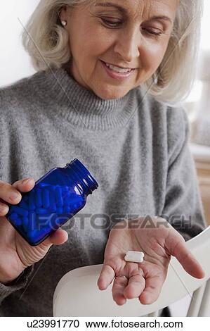 Senior woman holding medicine bottle View Large Photo Image Stock Image - Senior woman holding medicine bottle. Fotosearch