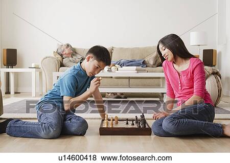 Stock Photo - Siblings playing chess game. Fotosearch