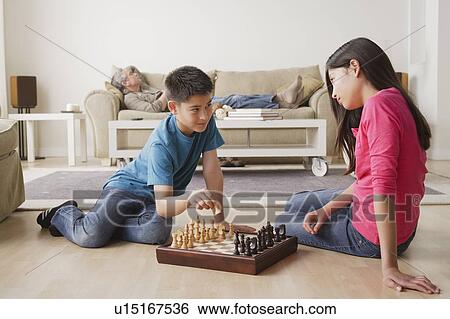 Stock Photograph - Siblings playing chess game. Fotosearch