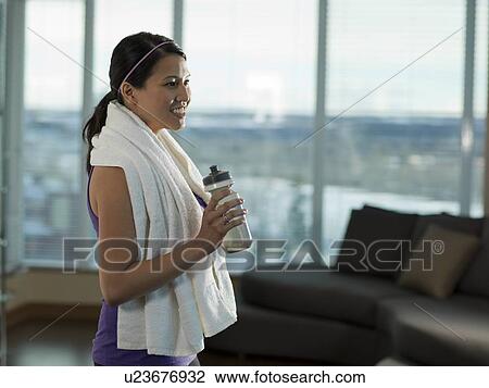 Stock Image - Side view of Young woman exercising at home. Fotosearch