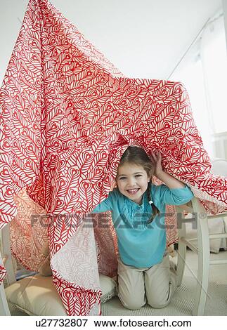 Stock Photo - Small girl (4-5 years) playing with curtain. Fotosearch