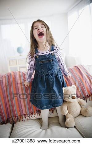 Small girl (4-5 years) standing on sofa View Large Photo Image Stock Photo - Small girl (4-5 years) standing on sofa. Fotosearch