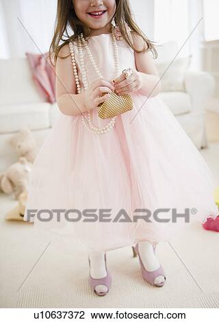 Stock Image - Small girl (4-5 years) wearing tulle dress and high heels. Fotosearch