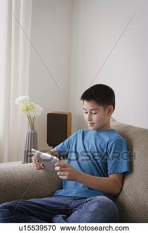 Smiling boy (10-11) using digital tablet View Large Photo Image Stock Image - Smiling boy (10-11) using digital tablet. Fotosearch