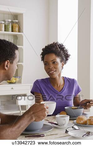 Smiling couple having breakfast together View Large Photo Image Stock Image - Smiling couple having breakfast together. Fotosearch