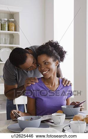 Smiling couple having breakfast together View Large Photo Image Stock Photograph - Smiling couple having breakfast together. Fotosearch