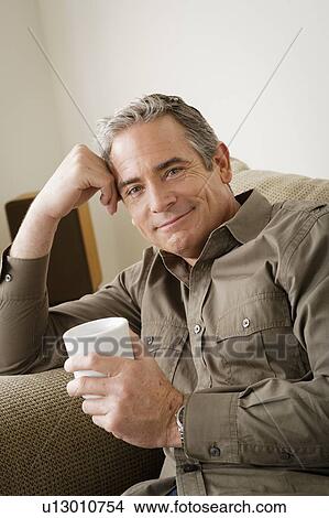 Smiling mature man holding mug View Large Photo Image Picture - Smiling mature man holding mug. Fotosearch