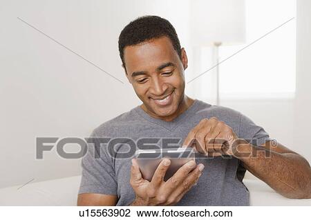 Smiling mature man using digital tablet View Large Photo Image Stock Image - Smiling mature man using digital tablet. Fotosearch