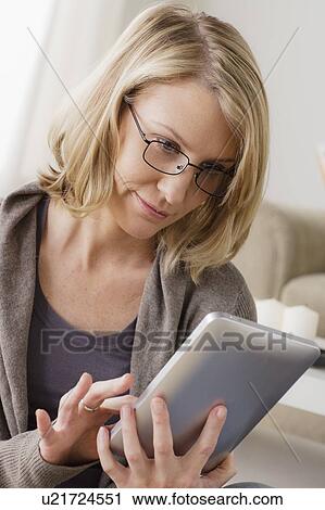 Smiling mid adult woman using digital tablet View Large Photo Image Stock Image - Smiling mid adult woman using digital tablet. Fotosearch