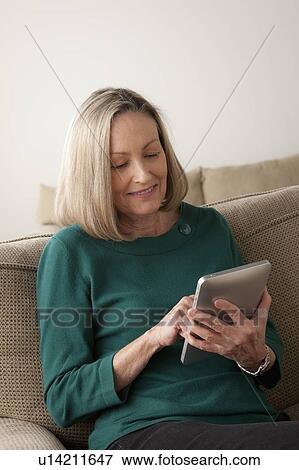 Smiling senior woman using digital tablet View Large Photo Image Stock Photo - Smiling senior woman using digital tablet. Fotosearch