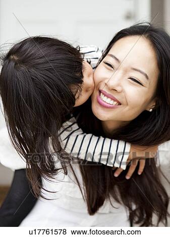 Smiling woman kissing by her daughter (4-5) View Large Photo Image Stock Photo - Smiling woman kissing by her daughter (4-5). Fotosearch