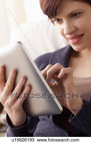 Stock Image - Smiling woman using digital tablet. Fotosearch