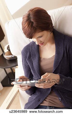 Smiling woman using digital tablet View Large Photo Image Stock Photo - Smiling woman using digital tablet. Fotosearch