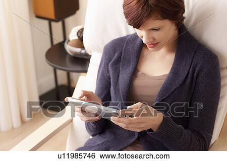 Smiling woman using digital tablet View Large Photo Image Stock Photograph - Smiling woman using digital tablet. Fotosearch
