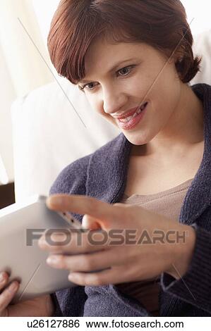 Smiling woman using digital tablet View Large Photo Image Stock Photograph - Smiling woman using digital tablet. Fotosearch