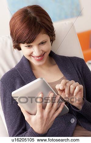 Smiling woman using digital tablet View Large Photo Image Stock Photography - Smiling woman using digital tablet. Fotosearch