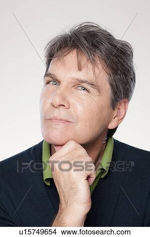 Picture - Studio portrait of mature man with hand on chin. Fotosearch