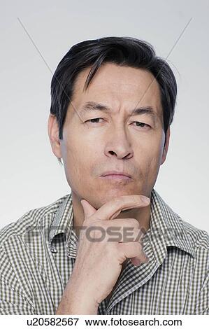 Studio portrait of mature man with hand on chin View Large Photo Image Stock Photo - Studio portrait of mature man with hand on chin. Fotosearch