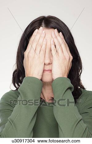 Studio portrait of mature woman covering eyes View Large Photo Image Picture - Studio portrait of mature woman covering eyes. Fotosearch