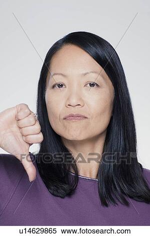 Studio portrait of mature woman showing thumbs down sign View Large Photo Image Stock Photography - Studio portrait of mature woman showing thumbs down sign. Fotosearch