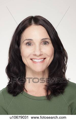 Stock Image - Studio portrait of mature woman smiling. Fotosearch