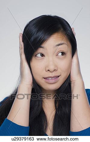 Studio portrait of young woman covering ears View Large Photo Image Stock Image - Studio portrait of young woman covering ears. Fotosearch