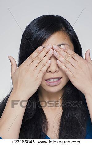 Studio portrait of young woman covering eyes View Large Photo Image Stock Photography - Studio portrait of young woman covering eyes. Fotosearch