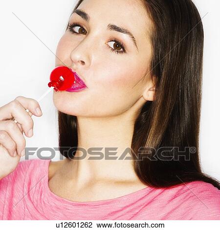 Studio portrait of young woman licking lollypop View Large Photo Image Stock Image - Studio portrait of young woman licking lollypop. Fotosearch