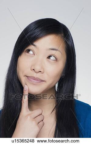 Studio portrait of young woman looking up View Large Photo Image Stock Photo - Studio portrait of young woman looking up. Fotosearch