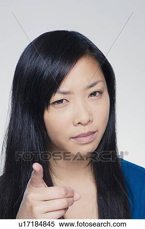 Studio portrait of young woman pointing finger View Large Photo Image Stock Photography - Studio portrait of young woman pointing finger. Fotosearch