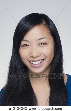 Stock Image - Studio portrait of young woman smiling. Fotosearch