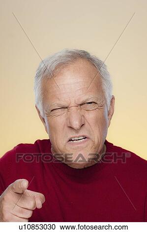Stock Image - Studio shot of angry senior man. Fotosearch