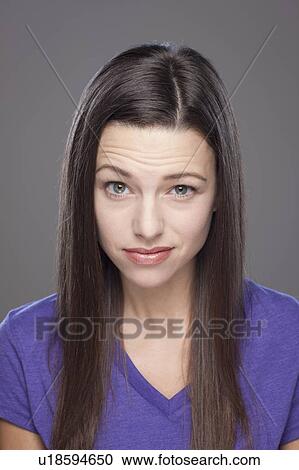 Stock Image - Studio shot of bored young woman. Fotosearch