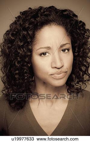 Stock Image - Studio shot of displeased mid adult woman. Fotosearch