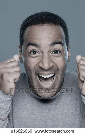 Stock Photograph - Studio shot of excited man. Fotosearch