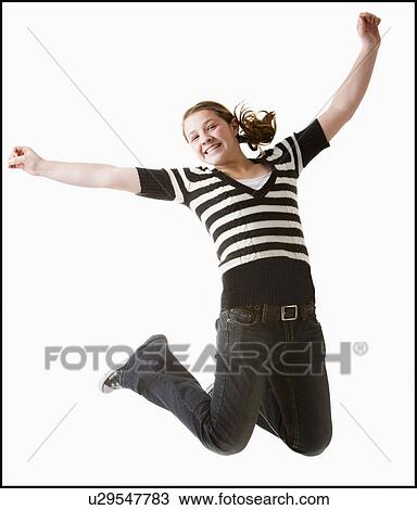 Stock Image - Studio shot of girl (12-13) jumping with arms raised. Fotosearch
