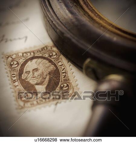 Stock Photo - Studio shot of magnifying glass and old post stamp. Fotosearch