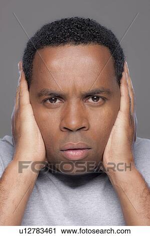 Studio shot of mid adult man covering ears View Large Photo Image Stock Image - Studio shot of mid adult man covering ears. Fotosearch