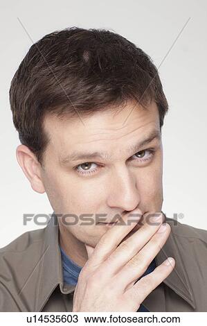 Studio shot of mid adult man covering lips View Large Photo Image Stock Image - Studio shot of mid adult man covering lips. Fotosearch