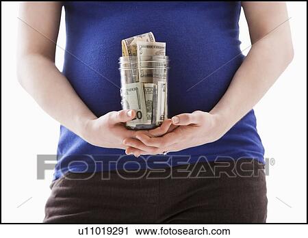 Studio Shot of mid section of pregnant woman holing jar with money View Large Photo Image Stock Image - Studio Shot of mid section of pregnant woman holing jar with money. Fotosearch