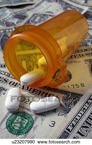 Stock Image - Studio shot of pill bottle and dollar banknotes. Fotosearch