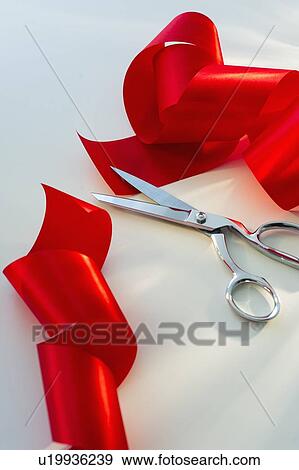 Stock Photo - Studio shot of red ribbon and scissors. Fotosearch