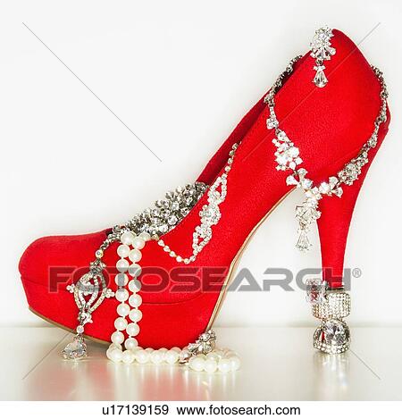 Stock Photo - Studio shot of red stiletto with jewelry. Fotosearch