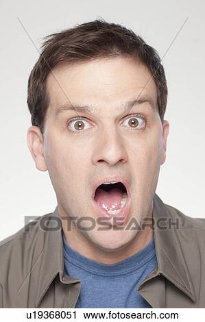 Stock Image - Studio shot of shocked mid adult man. Fotosearch