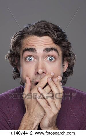 Stock Image - Studio shot of shocked young man. Fotosearch
