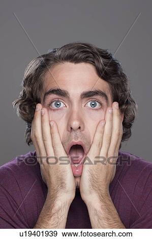 Stock Photo - Studio shot of shocked young man. Fotosearch