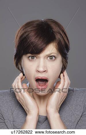 Studio shot of shocked young woman View Large Photo Image Stock Image - Studio shot of shocked young woman. Fotosearch