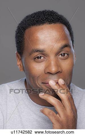 Stock Image - Studio shot of smiling mid adult man. Fotosearch