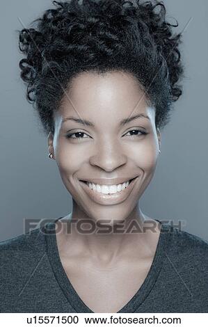 Stock Image - Studio shot of smiling young woman. Fotosearch