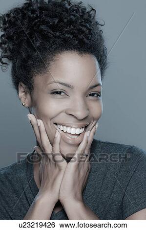 Stock Photograph - Studio shot of smiling young woman. Fotosearch